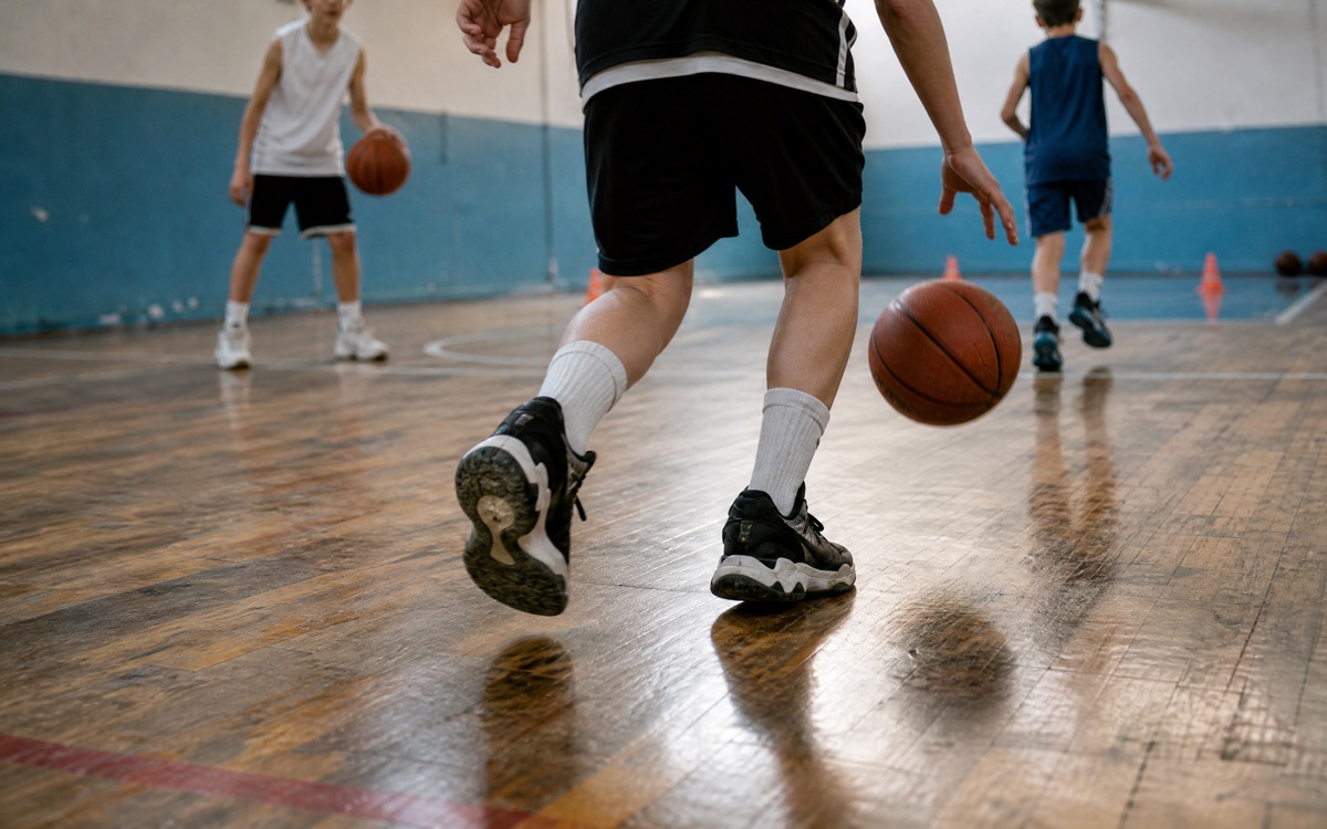 Basketbol çalışmasında zıplayan top ve parke üzerinde spor ayakkabılar